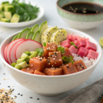 Watermelon Poke Bowl: A Plant-Based Twist on a Hawaiian Classic 3 A vibrant watermelon poke bowl featuring marinated watermelon cubes, crispy tofu, edamame, sliced radishes, cucumber, avocado, and sesame seeds.